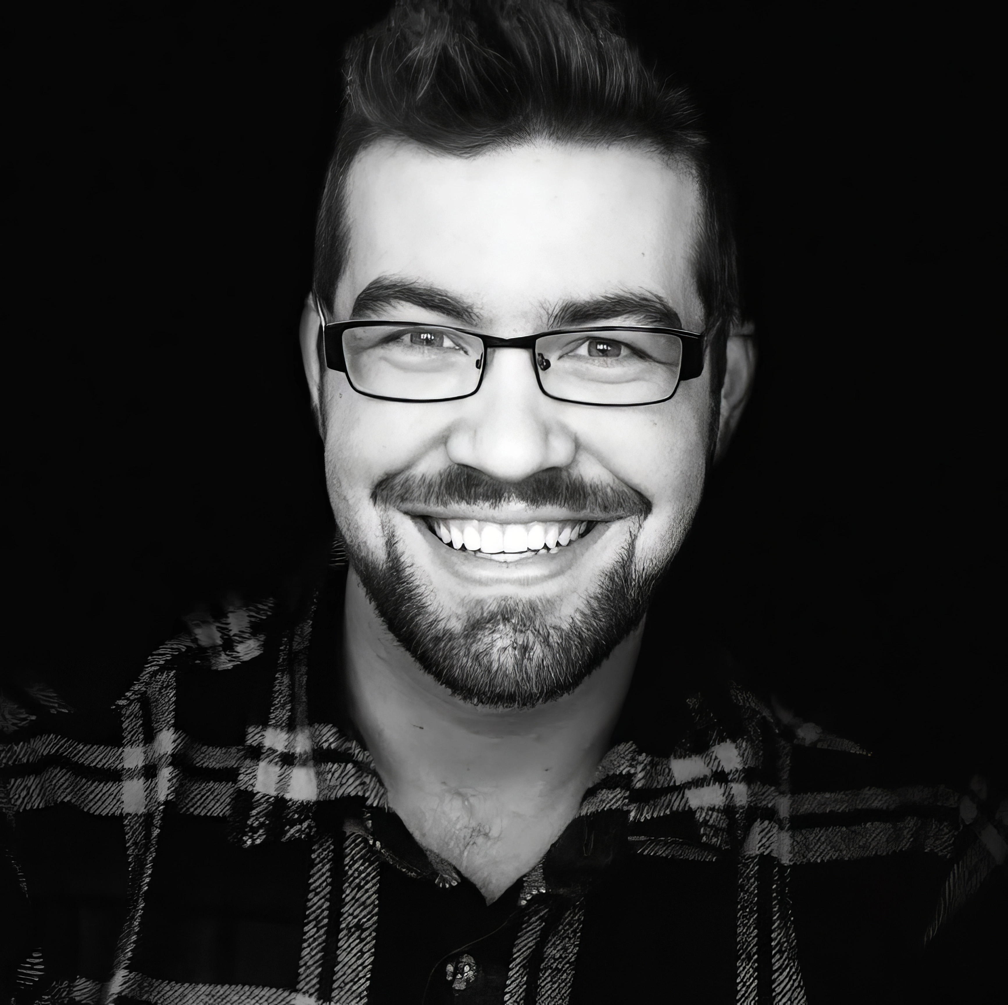 Black-and-white headshot of photographer Jonathan Schmidt smiling at the camera.