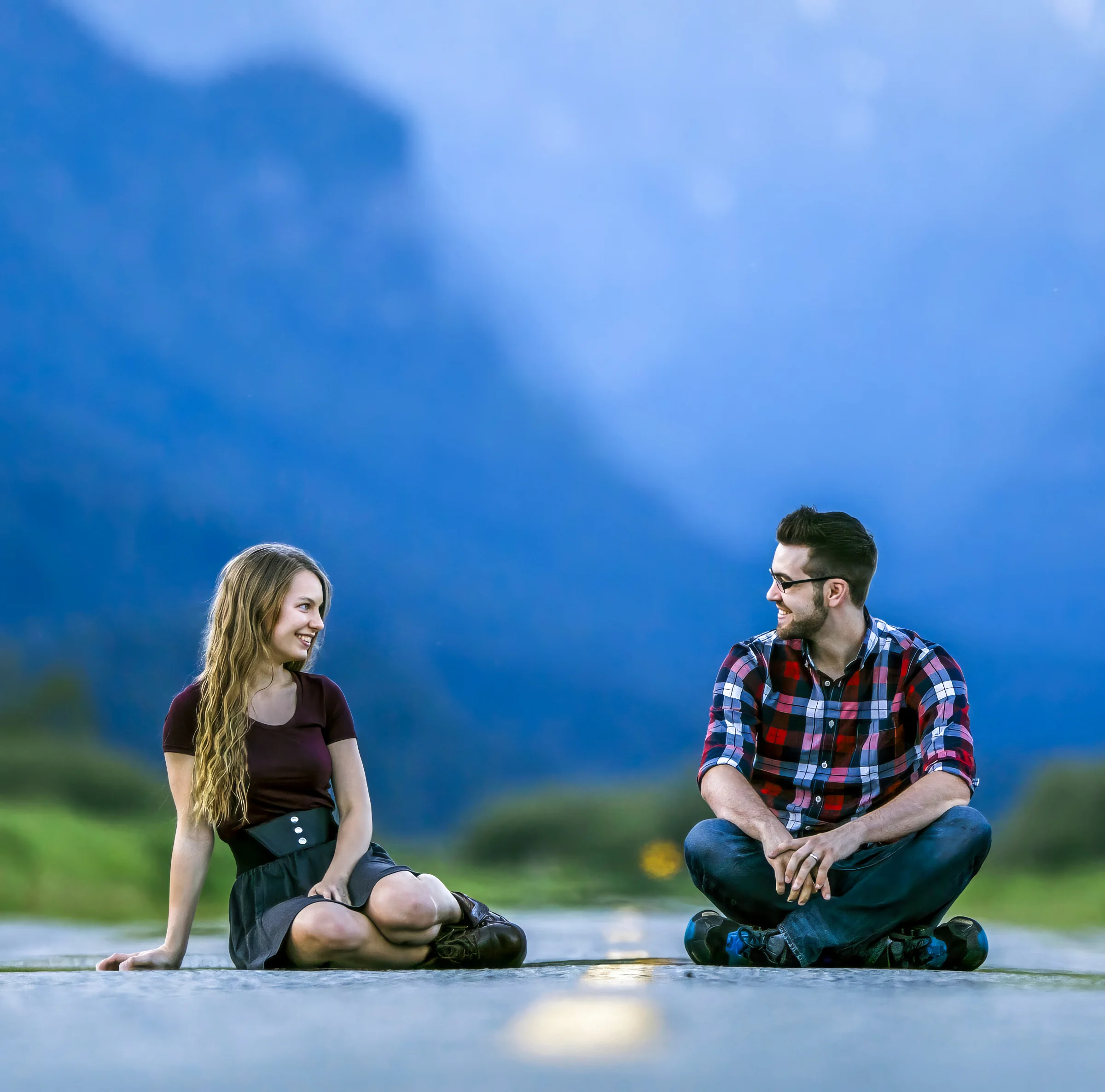 Restored colour portrait of a couple seated beside a mountain road.